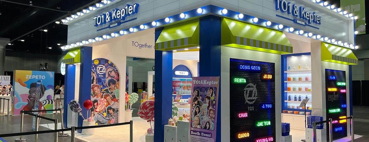 Colorful TO1 & Kep1er booth with bright lights, candy props, and vibrant signage.