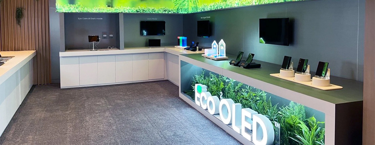 ChatGPT said: Eco OLED trade show booth with green-themed visuals and illuminated signage.