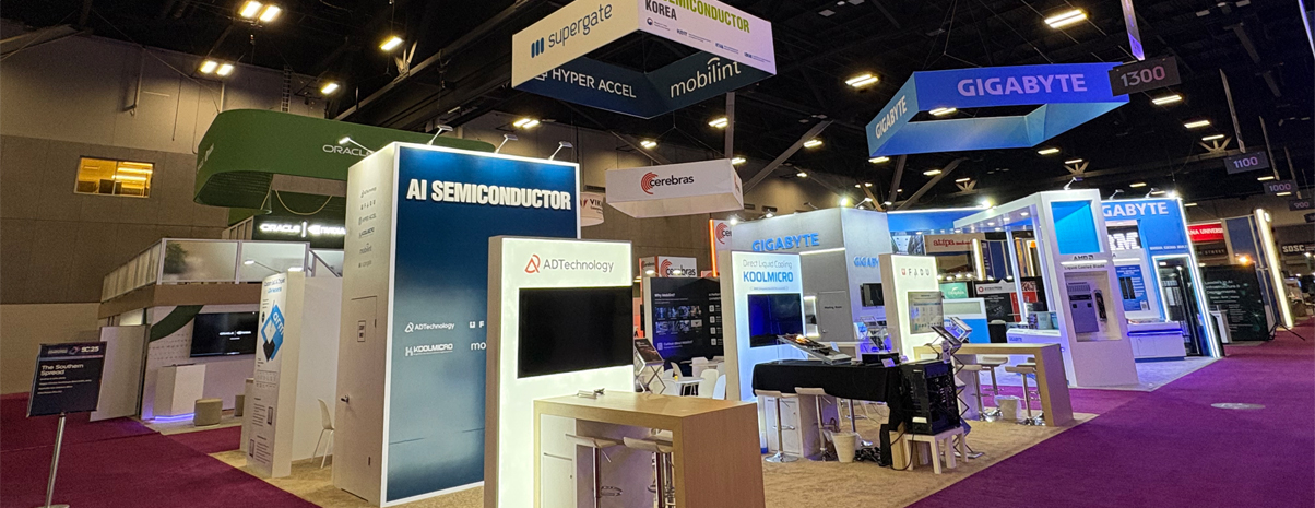 custom exhibit booth with overhead signage and tech displays