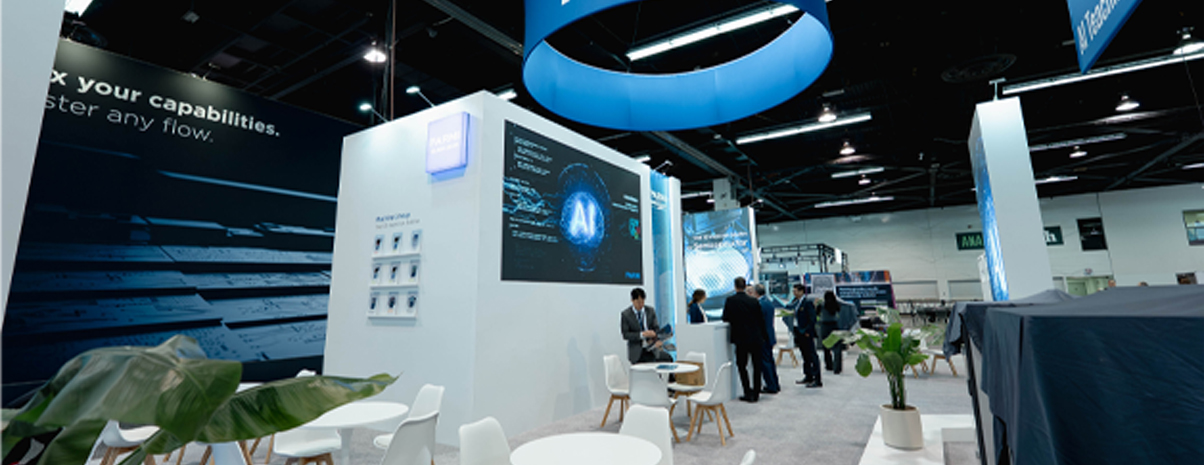 Custom trade show booth with overhead signage and open seating area on show floor