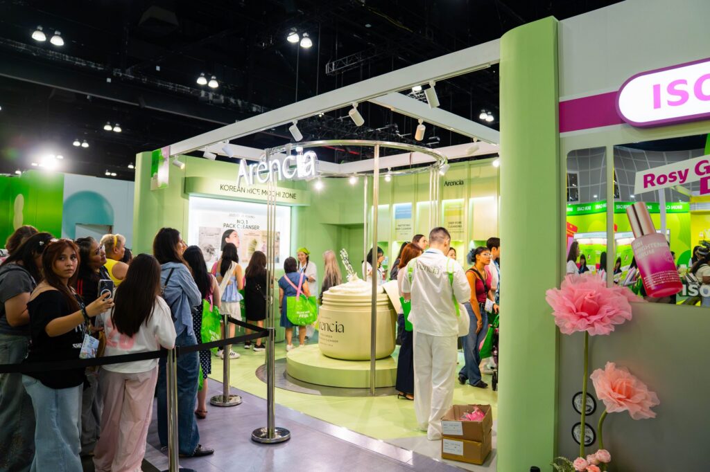 Arencia Korean rice skincare booth with oversized product display and pink floral props at Olive Young Festa