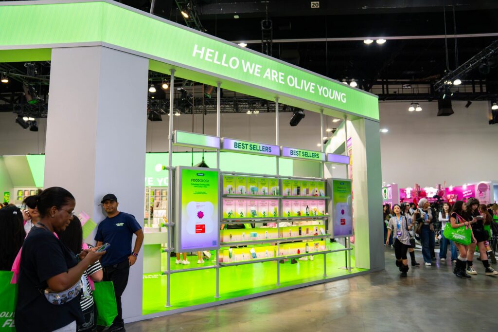 Hello We Are Olive Young overhead sign and Best Sellers product shelving wall at Olive Young Festa KCON LA 2026