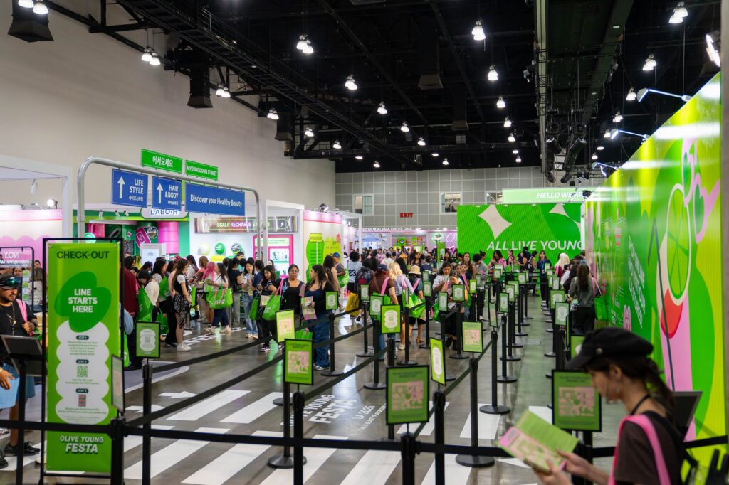 Check-Out queue with Line Starts Here signage and stanchions at the Olive Young Festa store