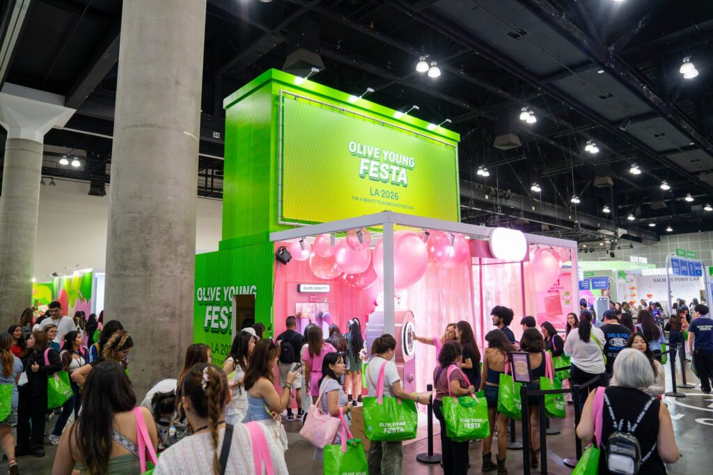 Olive Young Festa LA 2026 tower sign above a pink balloon booth with attendee queue