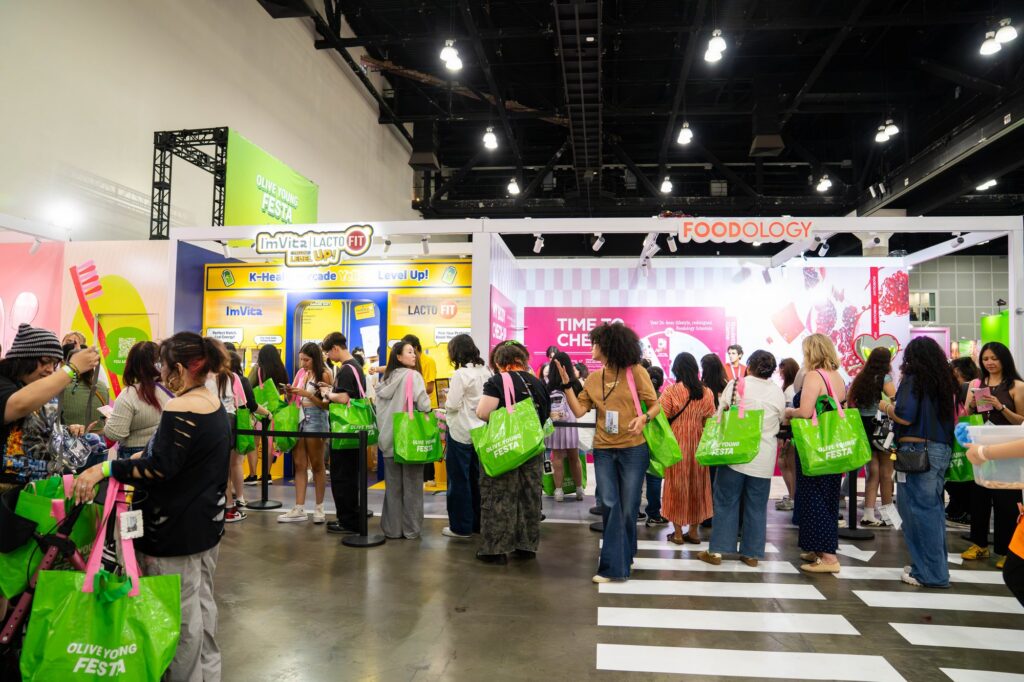 Foodology and ImVita wellness booths with attendees and crosswalk floor graphic at Olive Young Festa