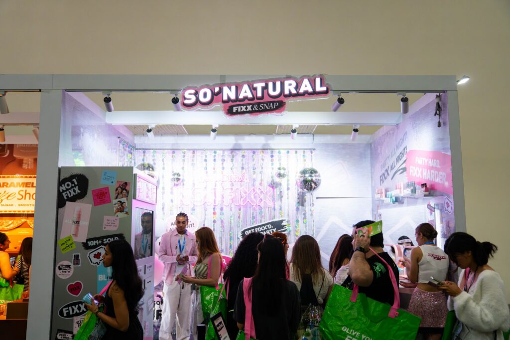 So Natural Fixx and Snap makeup booth with disco ball and party graphics at Olive Young Festa