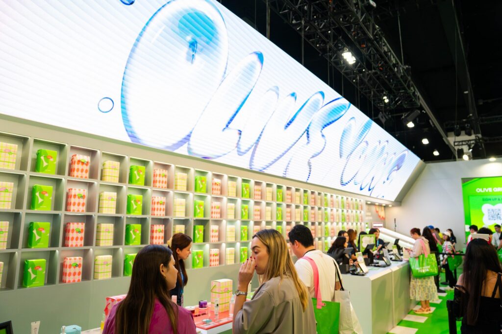 Olive Young store with animated LED header wall and green product shelving at KCON LA 2026