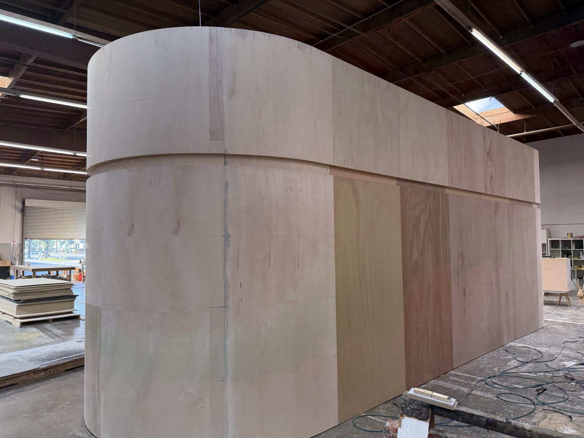 Raw plywood structure of the Medicube booth with curved walls in the Beaver XP shop