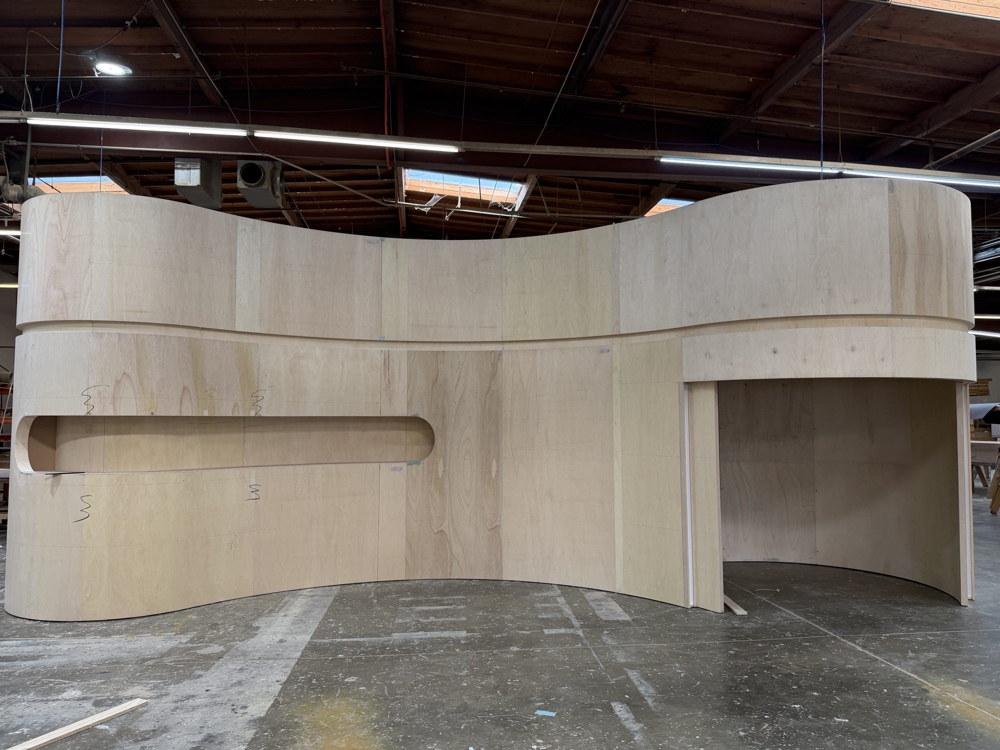 S-curve plywood wall with a recessed product display niche
