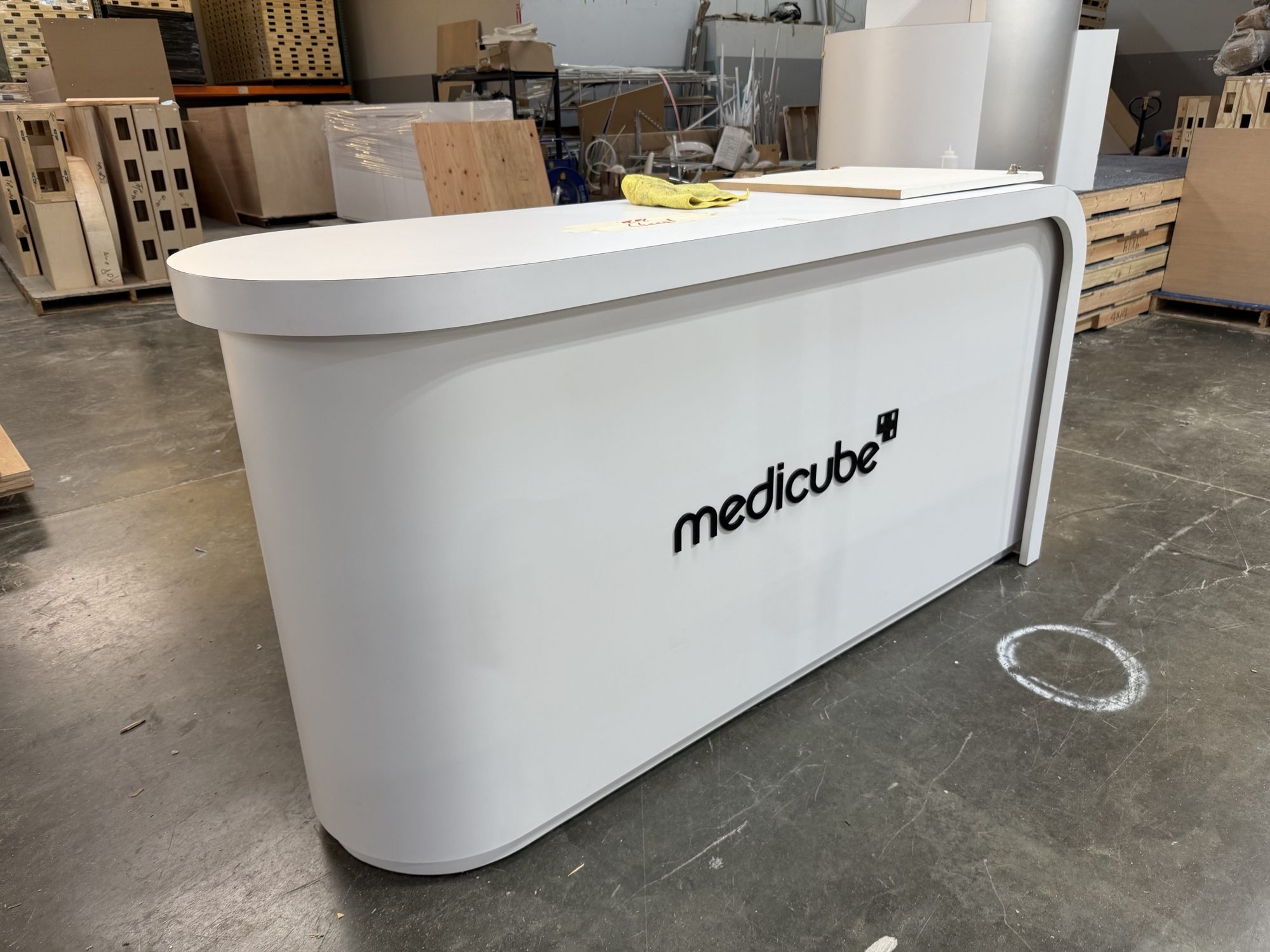 Custom white Medicube reception counter with rounded ends