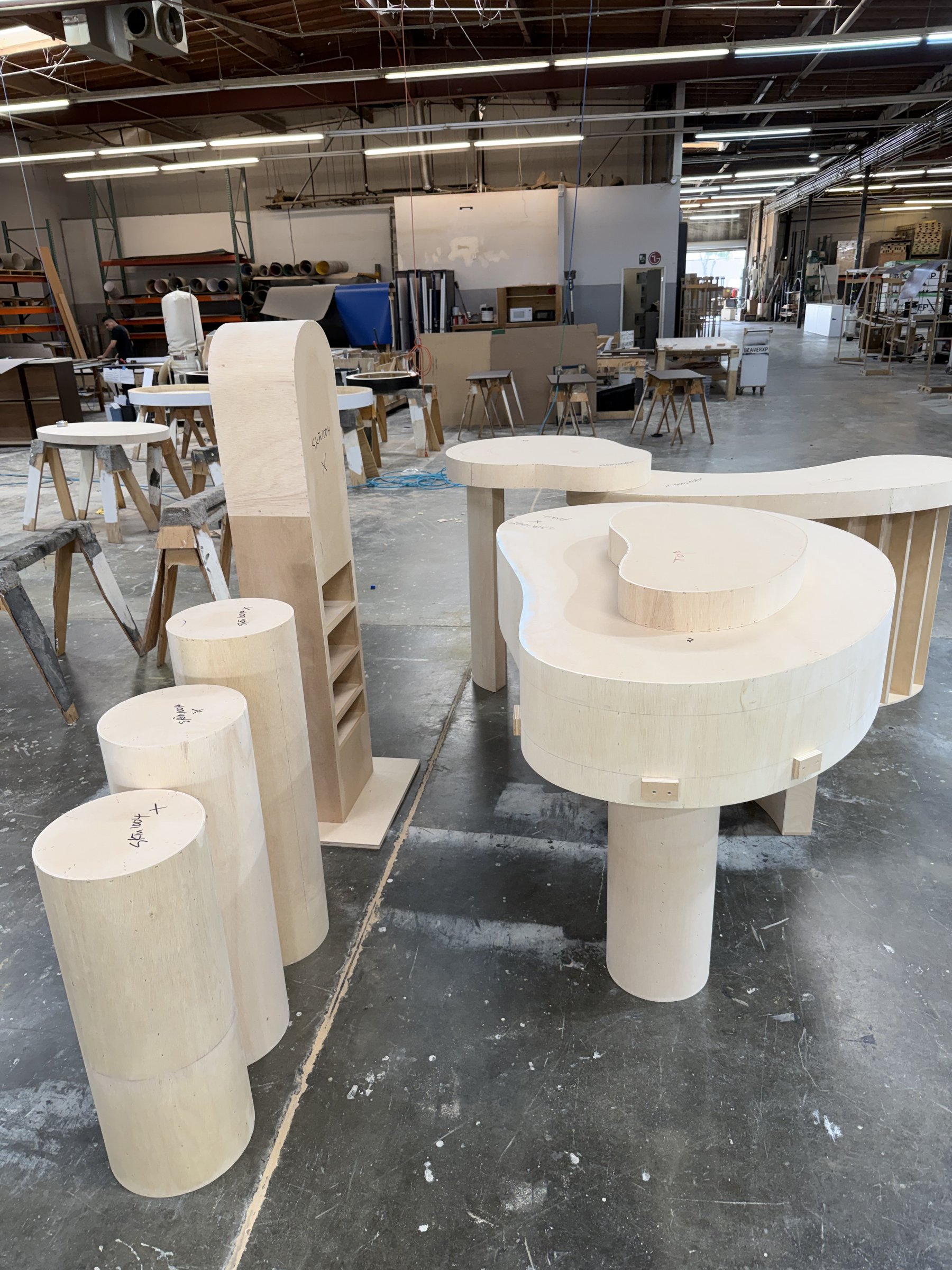 Raw plywood builds of SKIN1004 booth furniture in the Beaver XP shop