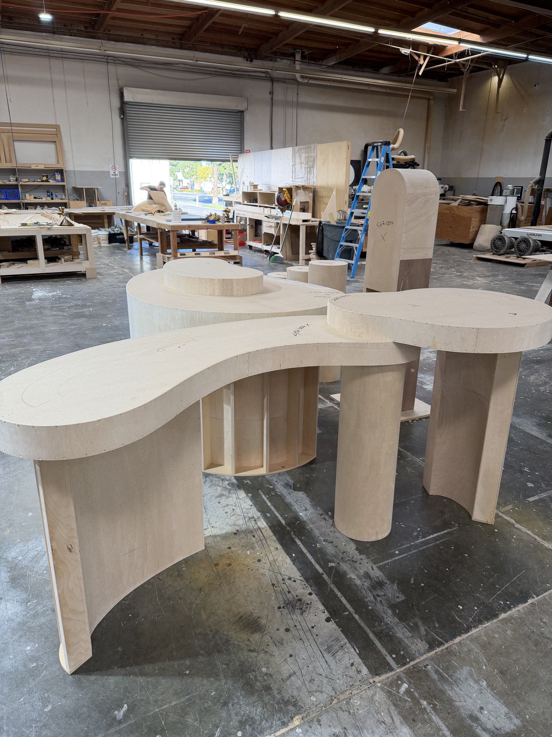 S-curve plywood table with column and curved-panel legs