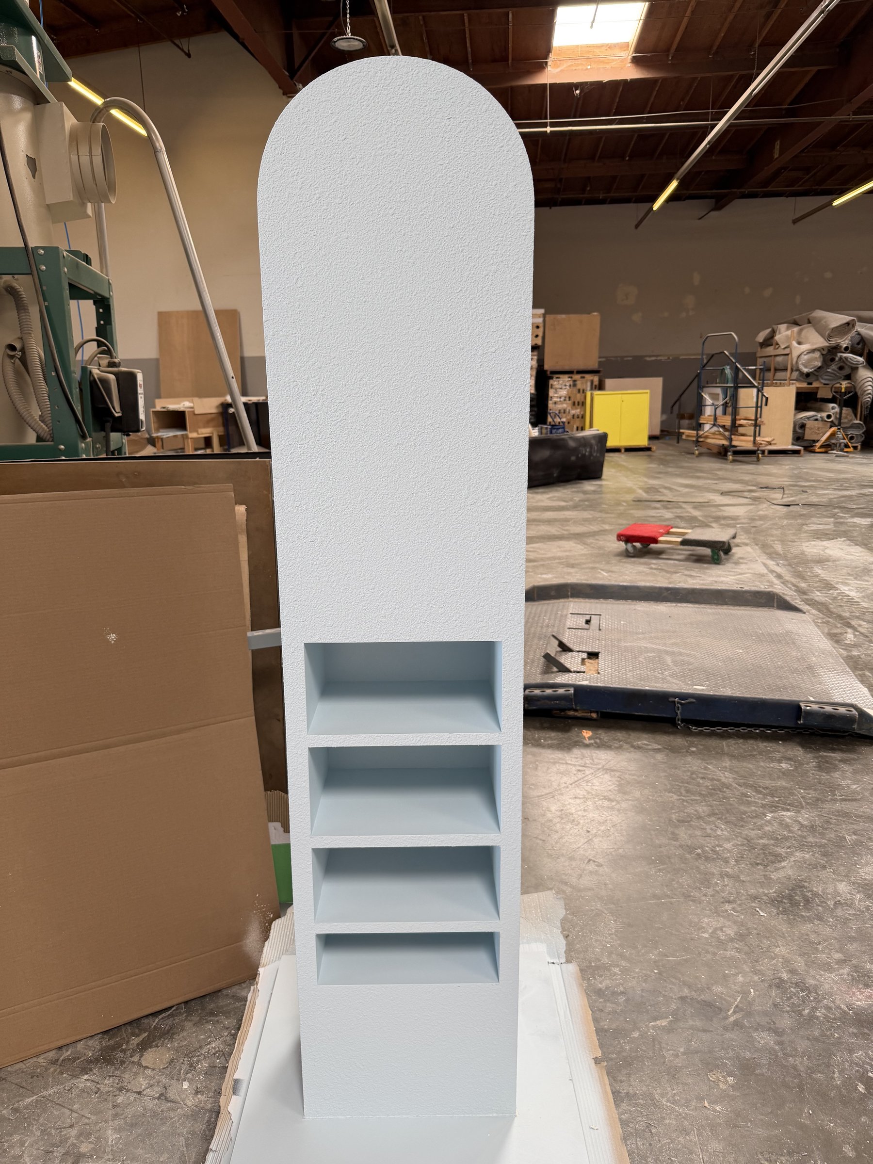 Painted arched display tower with four product niches